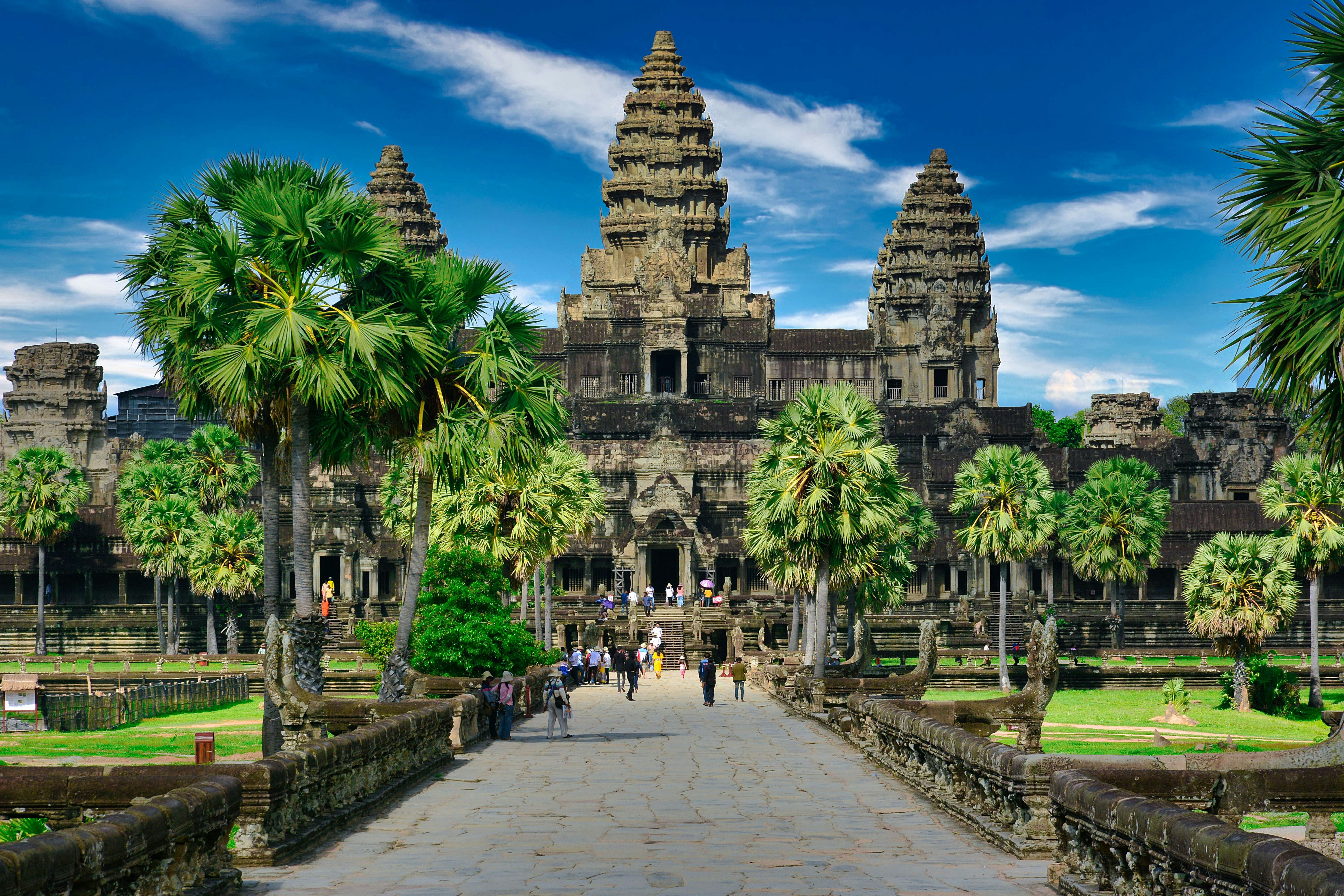 View of Angkor Wat's towers reflected in a lotus-filled pond